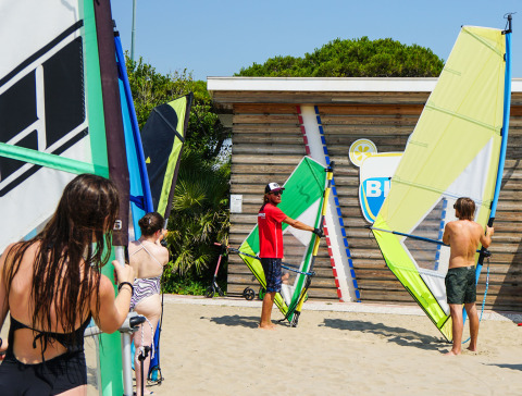 Istruttore insegna windsurf sulla spiaggia del Camping Union Lido Mare, Veneto, Italia.