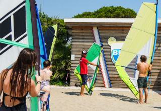 Instruktør underviser gruppe i windsurfing på stranden ved Camping Union Lido Mare, Veneto, Italien.