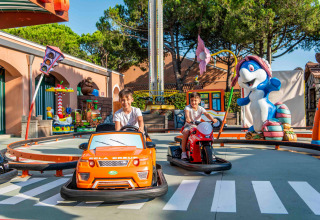 Kinderen genieten van mini-auto’s en motorfietsen in Camping Union Lido Mare, Veneto, Italië.
