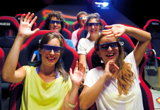 Happy young people wearing 3D glasses enjoy an immersive ride at Camping Union Lido Mare in Veneto, Italy.