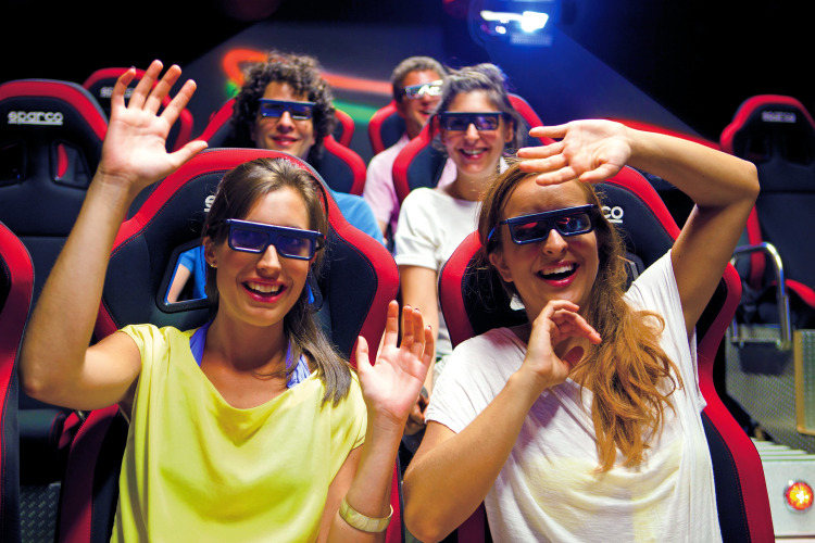 Vrolijke jongeren met 3D-brillen genieten van een attractie op Camping Union Lido Mare in Veneto, Italië.