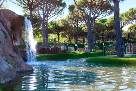 Cascata e laghetto circondato da alberi al Camping Union Lido Mare, parco vacanze in Veneto, Italia.