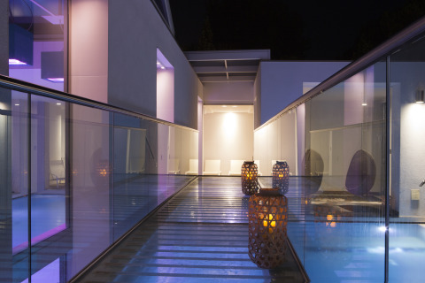 Night view of a modern glass walkway with lanterns and ambient lighting at Camping Union Lido Mare in Veneto, Italy.