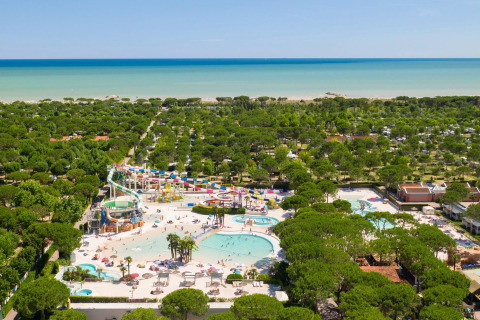 Vista aerea di Camping Union Lido Mare in Veneto, Italia, con piscine, scivoli e la spiaggia sullo sfondo.