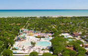 Aerial view of Camping Union Lido Mare in Veneto, Italy, featuring pools, water slides, trees, and the sea.