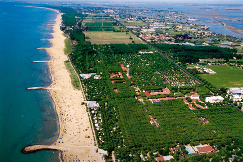 Vista aerea di Camping Union Lido Mare, villaggio turistico sulla spiaggia in Veneto, Italia, circondato dal verde.