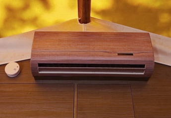 Aire acondicionado y detector de humo en la pared de madera de una tienda glamping con fondo soleado.