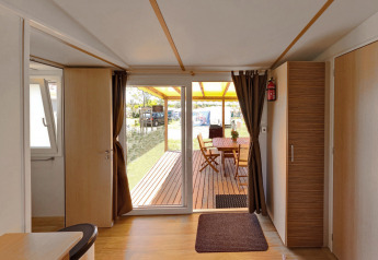 Vista interna del SunLodge Aspen Combi al Camping Vilanova Park in Spagna, con patio e zona pranzo esterna.