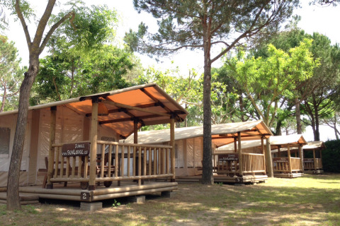SunLodge Jungle bij Camping Union Lido Mare in Italië, houten lodges omringd door groen en bomen.