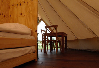 Indretningen af en hyggelig safari-telt med træmøbler hos Smûk Grutte Bell Tent, Smûk Recreatie, Holland.