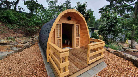 Cabaña de madera en Camping Roland, un parque vacacional en Limburgo, Países Bajos, entre árboles.