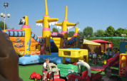 Speelplein met kleurrijk opblaasbaar piratenschip in Camping Village Marina di Venezia, Italië.