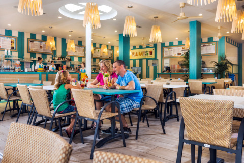 Famiglia che gusta drink colorati al ristorante luminoso del Camping Village Marina di Venezia, Veneto, Italia.