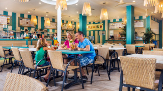 Familia disfruta de bebidas en un restaurante luminoso en Camping Village Marina di Venezia, Véneto, Italia.