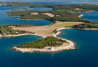 Luftfoto af Camping Village Marina di Venezia feriepark med grønne skove og blå bugter i Veneto, Italien.