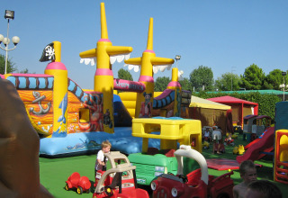 Børn leger på en farverig legeplads med oppusteligt piratskib i Camping Village Marina di Venezia, Italien.