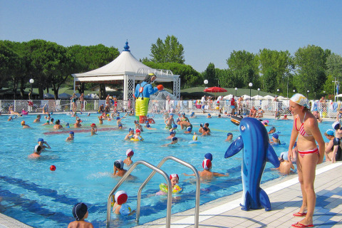 Children playing in the swimming pool at Camping Village Marina di Venezia, Veneto, Italy during summer.