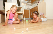 Dos niños juegan en el suelo de una moderna cabaña SunLodge Redwood en Camping Village Marina di Venezia, Italia.