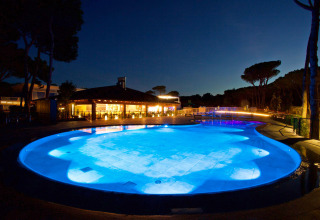 Oplyst swimmingpool om aftenen på Camping Village Cavallino feriestedet i Veneto, Italien.