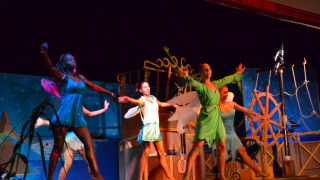 Actuación teatral de Peter Pan en Camping Village Cavallino con actores disfrazados en colorido escenario.