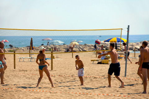 Vakantiegangers spelen beachvolleybal op het strand bij Camping Village Cavallino in Veneto, Italië.