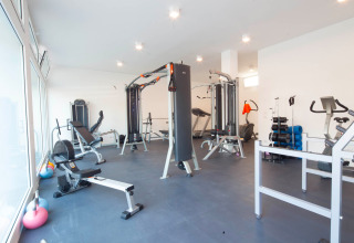 Moderne fitnessrum med træningsudstyr og naturligt lys på Camping Village Cavallino i Veneto, Italien.