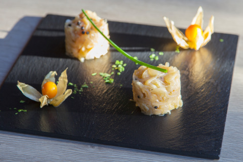 Piatto gourmet su lavagna nera con frutti e decorazione, Camping Village Cavallino in Veneto, Italia.
