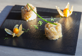 Piatto gourmet su lavagna nera con frutti e decorazione, Camping Village Cavallino in Veneto, Italia.