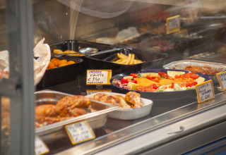 Buffet-style food including roast chicken, fries and salad at Camping Village Cavallino in Veneto, Italy.
