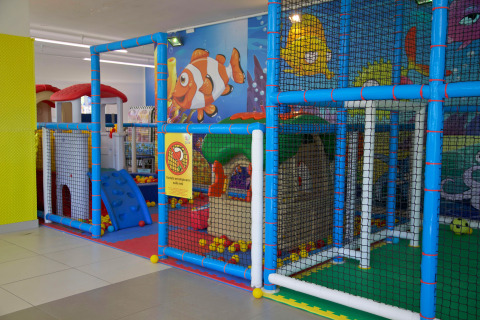 Indoor playground with colorful playhouses and safety nets at Camping Village Cavallino in Veneto, Italy.
