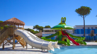 Zona de juegos con toboganes y piscina infantil en el Camping Village Cavallino, parque vacacional en Véneto, Italia.