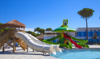 Zona de juegos con toboganes y piscina infantil en el Camping Village Cavallino, parque vacacional en Véneto, Italia.