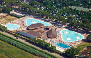 Vista aérea de hu Park Albatros Village en la Toscana, Italia, mostrando grandes piscinas y visitantes.