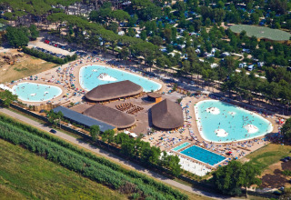 Vista aerea del hu Park Albatros Village in Toscana con grandi piscine affollate di visitatori.