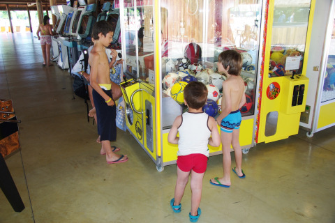 Kinderen spelen aan een grijpmachine in Hu Park Albatros Village, een vakantiepark in Toscane, Italië.