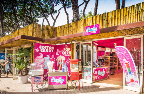 Colorful candy store at hu Park Albatros Village in Tuscany, Italy, with cotton candy and popcorn outside.