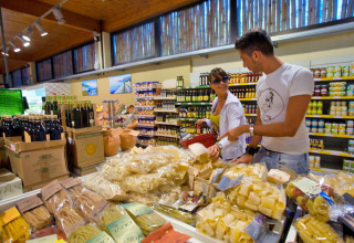 Couple shopping for pasta and olive oil in a supermarket at hu Park Albatros Village in Tuscany, Italy.