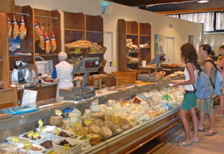 Clienti fanno acquisti al banco gastronomia del Park Albatros Village, villaggio vacanze in Toscana, Italia.
