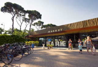 Billede af markedet ved hu Park Albatros Village feriepark i Toscana, Italien, med cykler og familier.