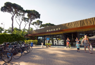 Foto van de markt bij hu Park Albatros Village vakantiepark in Toscane, Italië, met gezinnen en fietsen.