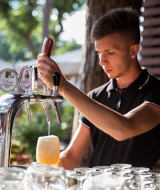 Un camarero sirve cerveza de barril en hu Park Albatros Village, un parque vacacional en la Toscana, Italia.