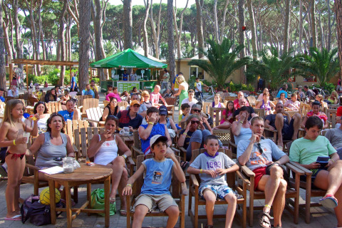 Persone sedute all'aperto presso hu Park Albatros Village, un villaggio turistico in Toscana, Italia.