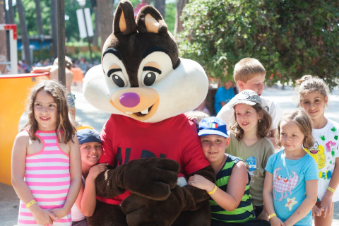 Children posing with a mascot at hu Park Albatros Village, a holiday park in Tuscany, Italy.