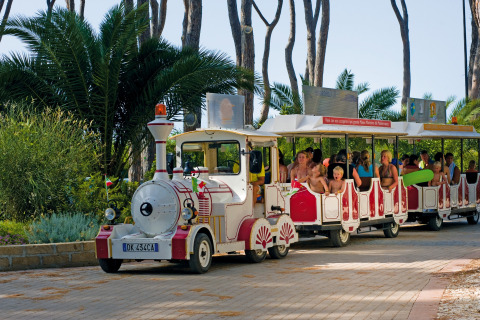 Enfants et adultes à bord d’un petit train touristique au hu Park Albatros Village, en Toscane, Italie.