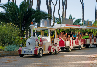 Enfants et adultes à bord d’un petit train touristique au hu Park Albatros Village, en Toscane, Italie.