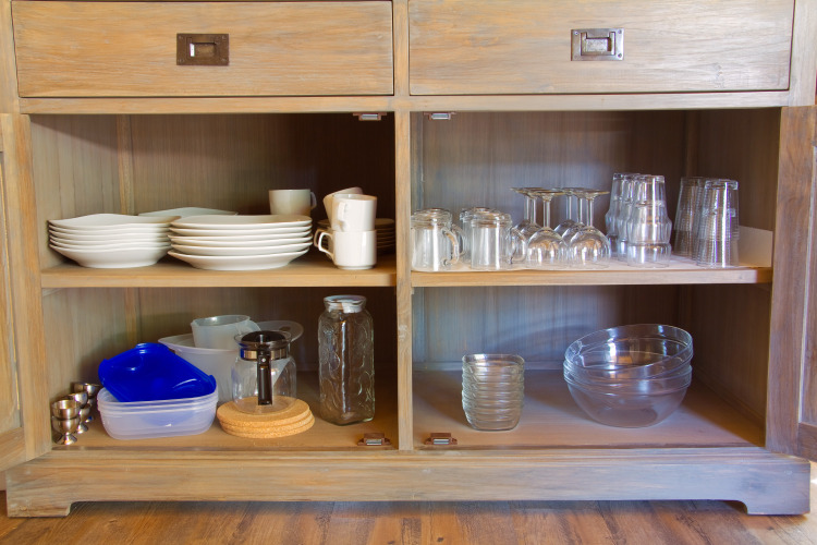 Armario abierto con platos, tazas, vasos y cuencos en SunLodge Jungle en Camping Village Cavallino, Italia.