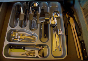 Cassetto portaposate con posate e utensili da cucina al SunLodge Jungle nel Camping Village Cavallino, Italia.
