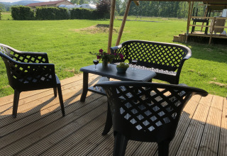 Terrasse mit schwarzen Gartenmöbeln, Wein und Blumen bei Safari-Zelt Camping de Regenboog, Tschechien