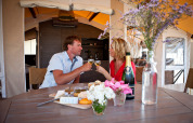Un couple déguste du vin et du fromage dans une tente de luxe à SunLodge Safari, Camping Village Cavallino, Italie.