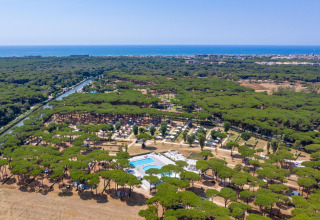 Luftfoto af Camping Village Roma Capitol feriepark i Italien med pool, træer og udsigt til havet.